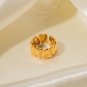 Detailed view of irregular golden heart ring on elegant white silk fabric