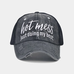 Detail of grey mesh trucker hat with hot mess embroidery and distressed brim texture