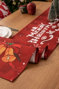 Detail of red plaid Christmas table runner with Merry Christmas print and holiday patterns