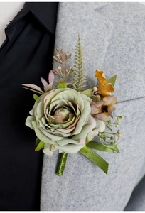 Detailed close-up of a faux sage green rose boutonniere pinned on a grey suit jacket
