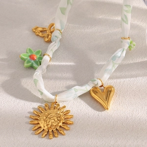 Collier doré 18 carats avec pendentifs soleil et fleur sur ruban à motif feuilles