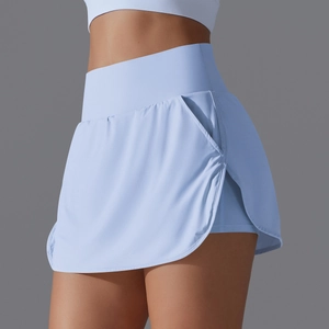 Detail of high-waisted light blue tennis skort showing side pocket and layering