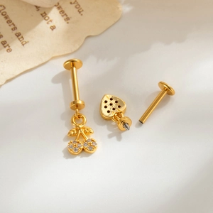 Elegant gold internally threaded labret stud with zircon cherry and heart pendant charms.