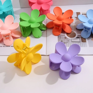 Macro detail of matte candy-colored flower hair claws with strong metal springs