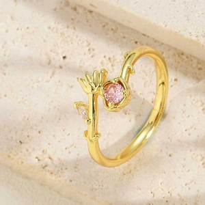 Detailed view of vine-shaped ring with pink zircon and leaf engravings on gold plating