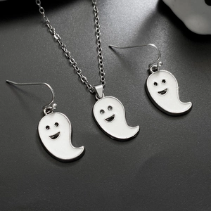 Detailed view of white enamel ghost necklace and earrings set with silver chains