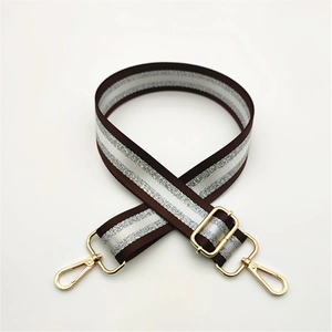 Detail of adjustable dark brown striped strap with glittering silver and gold metal hooks