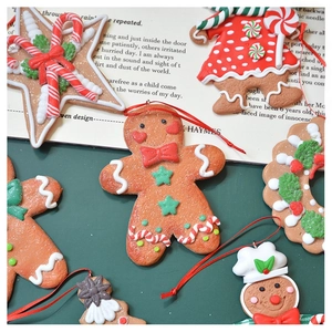 Close-up of clay gingerbread man ornaments with star and wreath for Christmas decor