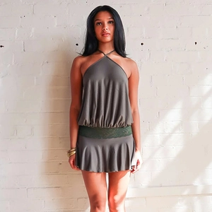 Détail de la robe grise dos nu avec taille en dentelle verte et ourlet à volants plissé
