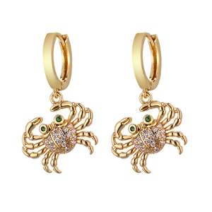 Detailed macro view of gold crab earrings with crystal rhinestones and green gem eyes