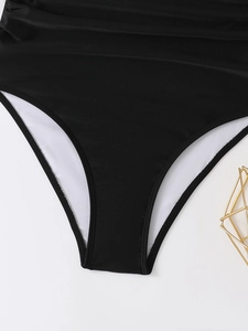 Dettaglio del fondo del costume nero con scollo a V con trama fine e fodera bianca