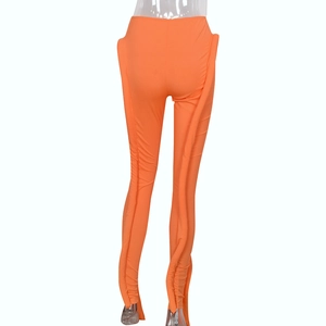 Detailaufnahme der orangefarbenen High-Waist-Hose mit seitlicher Raffung und Rippstrick