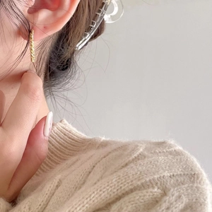 Elegant gold twisted rope hoop earrings worn by a model with a cozy knit sweater