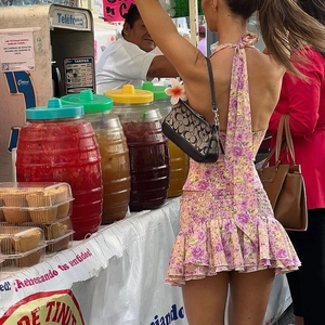 Detail of pink floral halter top and ruffled mini skirt set in an outdoor market setting
