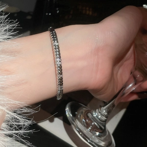 Detail of twisted silver bangle with shimmering zircon stones worn on wrist