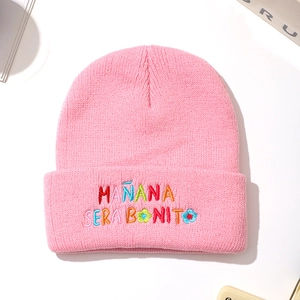 Pink knit beanie with Mañana Será Bonito colorful embroidery on a white background