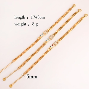 Detalle de pulseras imperdibles doradas con ojo turco y piedras de circón brillante