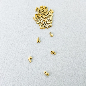 Close-up of golden stainless steel lowercase alphabet charms for DIY jewelry making