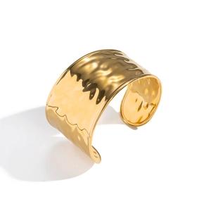 Minimalist wide hammered open bangle in 18K gold-plated stainless steel on white backdrop