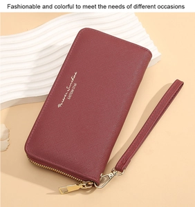 Detail view of burgundy cross-pattern long wallet with golden zipper and wrist strap
