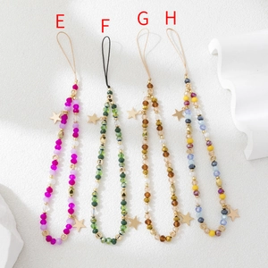Close-up of four beaded phone charms with faceted crystals and gold star pendants