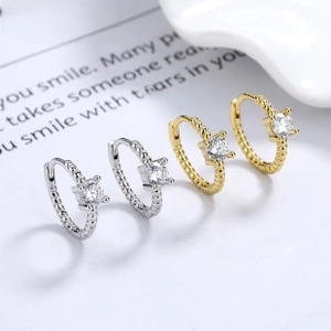 Detail view of gold and silver twisted rope hoop earrings with square zircon stone inlay