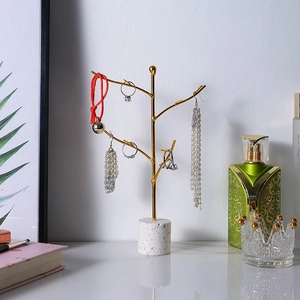 Golden T-bar jewelry stand with marble base for organizing necklaces and earrings