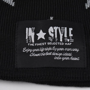 Close-up of black ribbed knit beanie featuring an 'IN STYLE' embroidered woven label