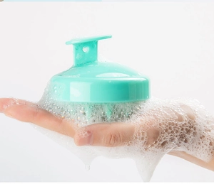 Detailed view of mint green silicone scalp brush creating rich lather for head massage