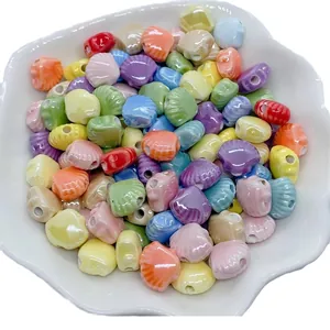 Colorful shell-shaped ceramic beads for DIY jewelry making in a white petal bowl