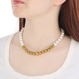 Detail of French vintage pearl and gold bead necklace worn on neck for a luxury look