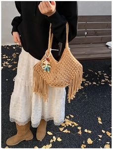 Close-up of khaki handmade woven cotton rope tote bag with bohemian tassel details
