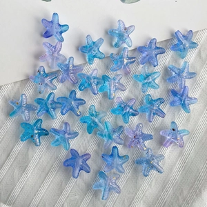 Close-up of blue-purple gradient starfish beads with gold glitter for DIY crafts