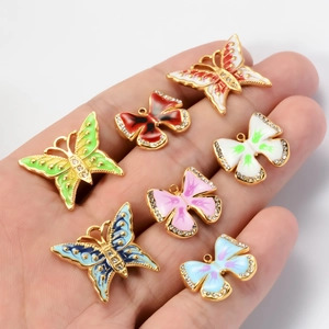 Handheld view of colorful butterfly charms with enamel and rhinestones in various sizes