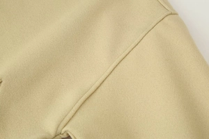 Detail shot of khaki wool jacket featuring precise stitching and soft textured fabric