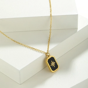 Detail of gold-plated necklace with a black rectangular pendant and zircon star