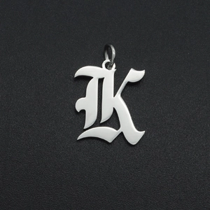 Macro detail of silver stainless steel gothic letter K pendant with polished finish