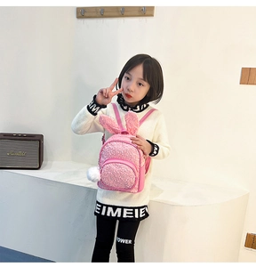 Pink sequin backpack for kids featuring cute rabbit ears and a soft fluffy pompom charm