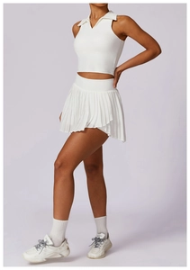 Detail of white sleeveless polo tank top and pleated tennis skirt set on a model