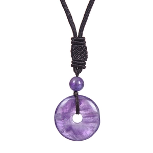 Detail of purple amethyst pendant with black woven cord and traditional knot design