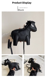 Detail of horse-shaped black leather crossbody bag with lychee texture and metallic tassel