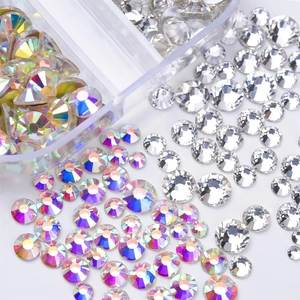 Macro shot of 12-grid nail art box showing mixed sizes of AB and clear crystal rhinestones