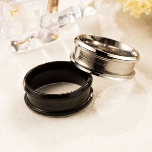 Detail of 8mm brushed silver and black stainless steel rings on a beige velvet surface