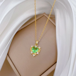 Close-up of heart-shaped green zircon pendant with pave crystals on gold-plated chain