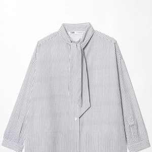 Women's black and white striped poplin shirt with a scarf-style tie neckline in flat lay