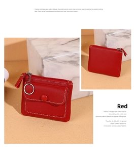 Detail of red small zipper wallet featuring white stitching and silver keychain ring