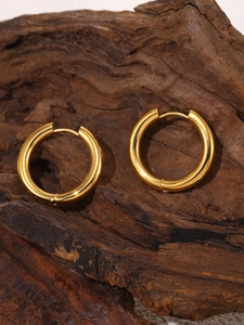 Detailed view of thick 18k gold plated hoop earrings on a rustic wooden display stand