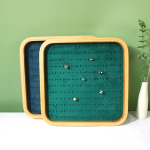 Bamboo jewelry display tray with green velvet slots for rings and earrings