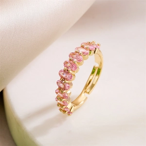 Adjustable gold open ring featuring pink zircon stones on a silk and stone background
