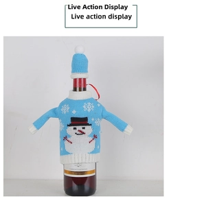 Detail of blue knitted Christmas wine bottle cover with snowman pattern and matching hat